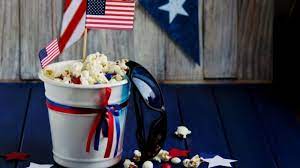 For decorative purposes only. An image depicting the American flag, popcorn, and sunglasses to illustrate the idea of a 4th July movie night for a new Independence Day tradition.