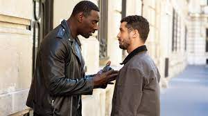 Assane Diop talking to Youssef Guédira, a police detective who uses his knowledge of the Arsène Lupin books to catch Diop.