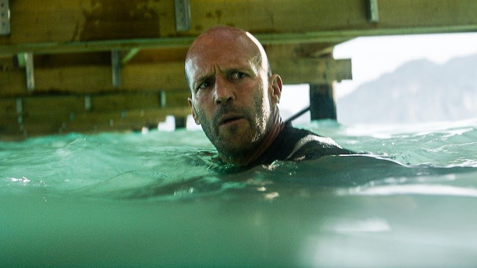Jason Statham as Jonas, looking wary. He is in the ocean, alone, aware that the Meg is somewhere nearby.